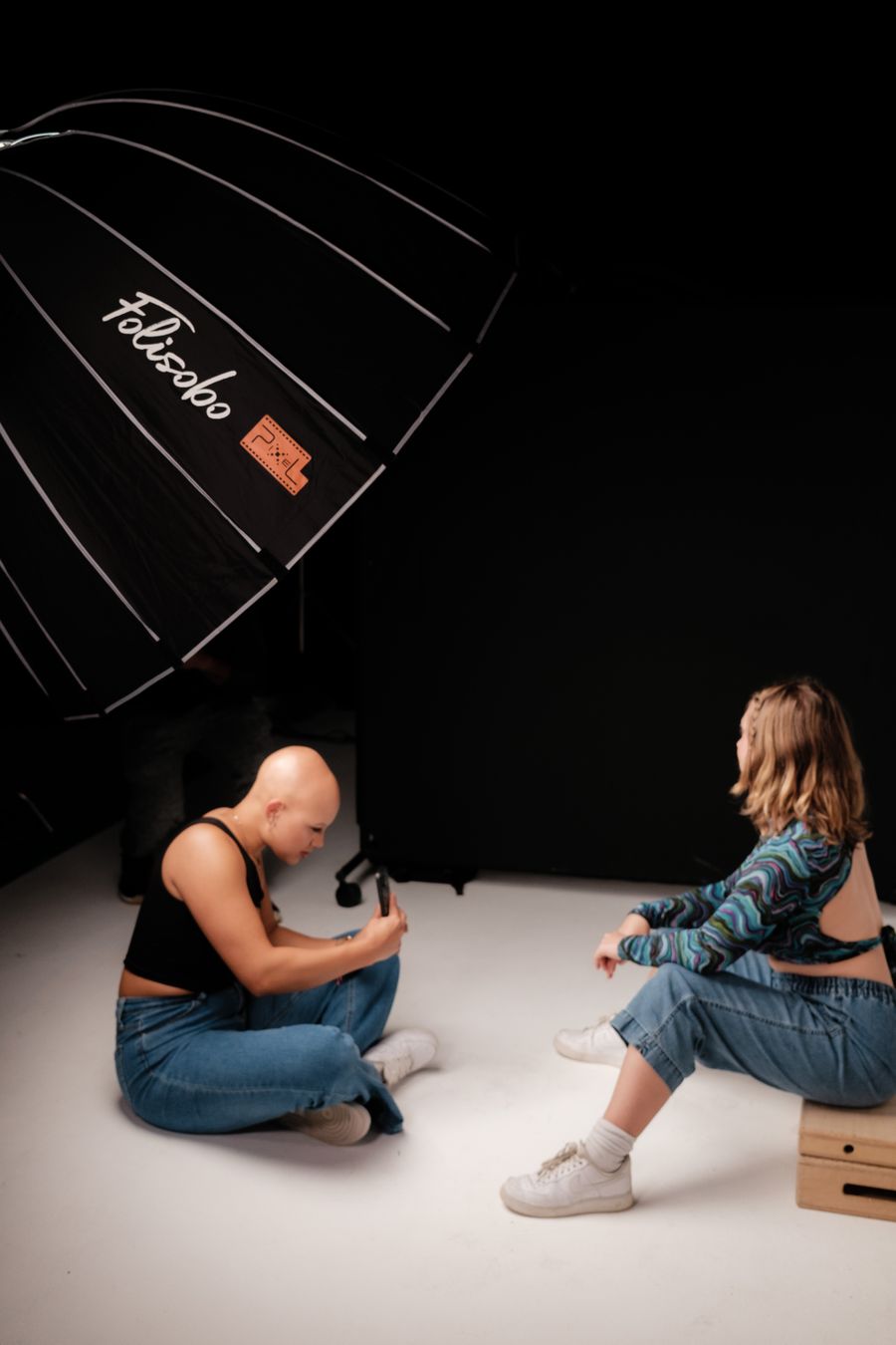 A photographer taking photos of the model sitting on a wooden platform — Add Text technique