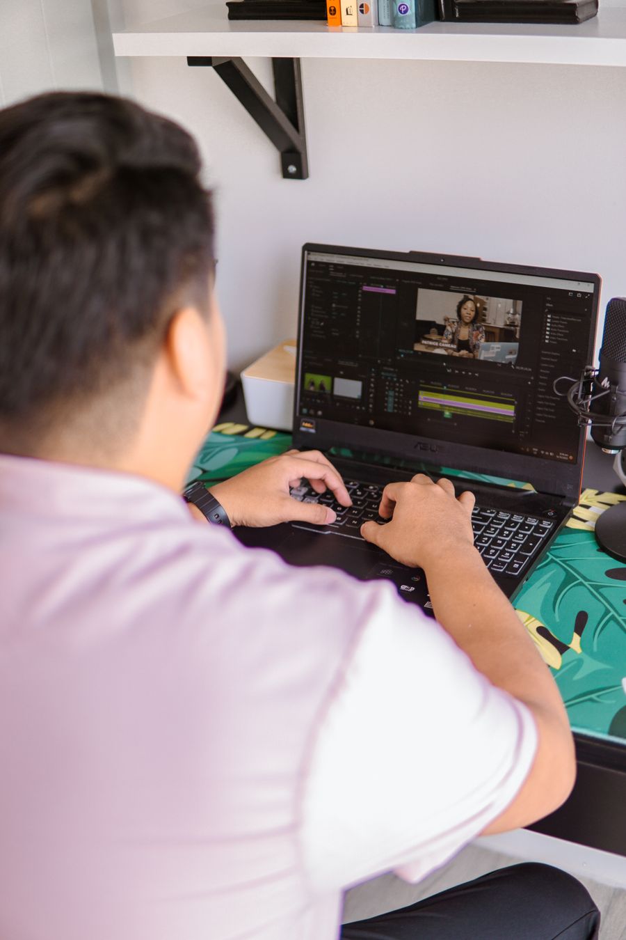 A man in pink shirt using laptop — PhotoAI Company — AI photo & design editor browser mockup