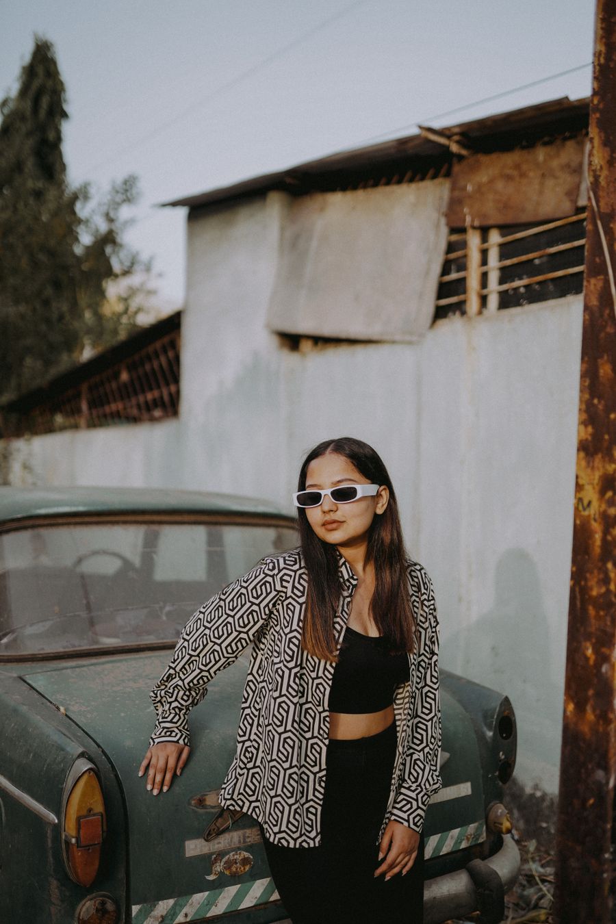Young woman posing next to an old abandoned car — stock photo for PhotoAI Company — AI photo & design editor