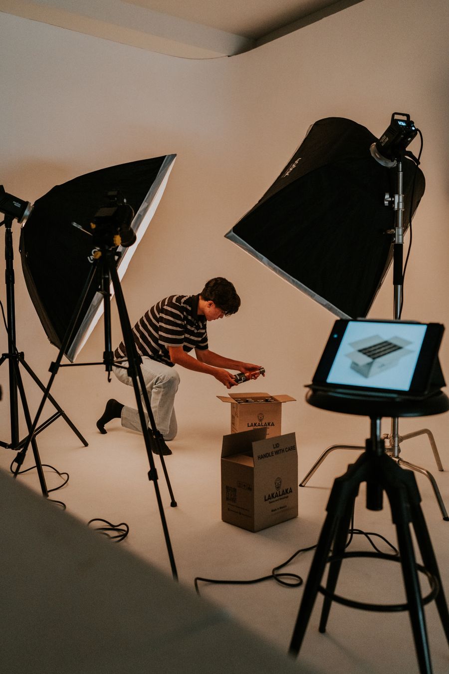 Studio shot of a man unboxing a package — PhotoAI Company — AI photo & design editor dashboard mockup