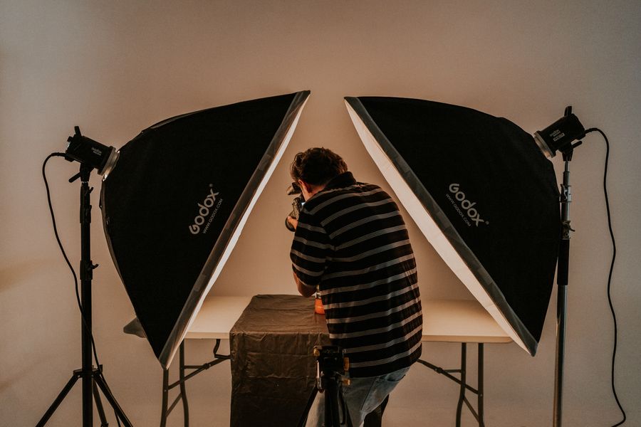 Photographer working with camera and studio light — after Add Text