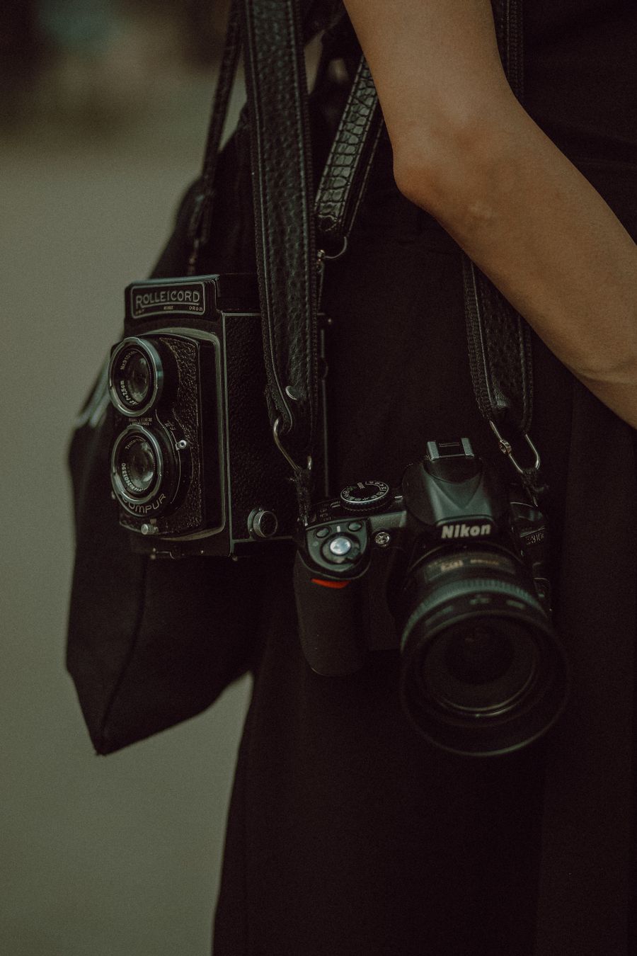 Cameras on leather straps hanging from persons shoulder — Add Text editor mockup