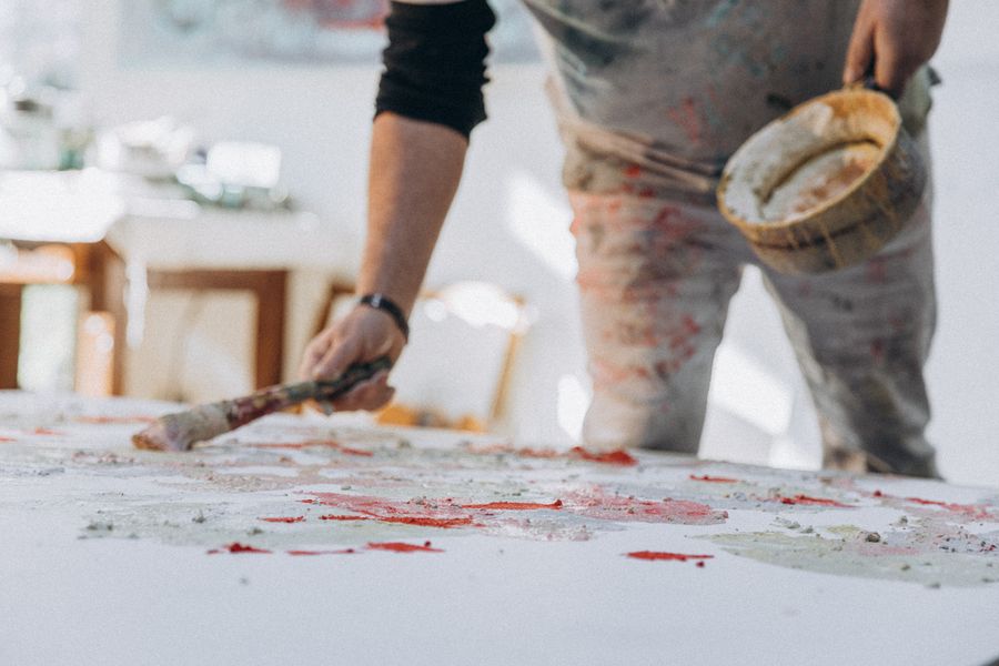 Brush on canvas held by a painter — Export a Design layers-panel mockup
