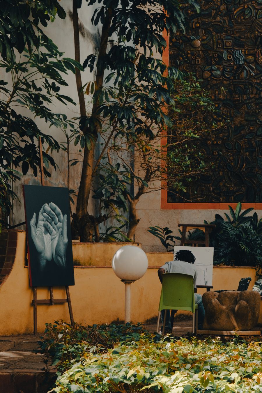 A person painting in a garden with plants — stock photo for Simple pricing, no watermarks, no gotchas