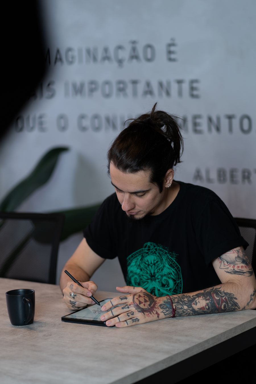 Creative tattooed artist using tablet indoors — Add Text annotated figure