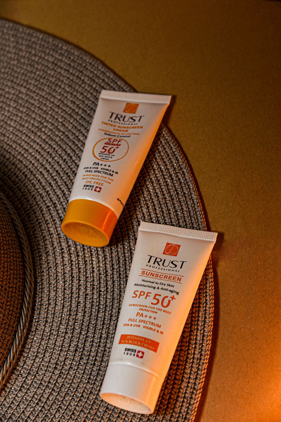 Spf 50 sunscreen tubes on woven mat surface — Export a Design template-card mockup