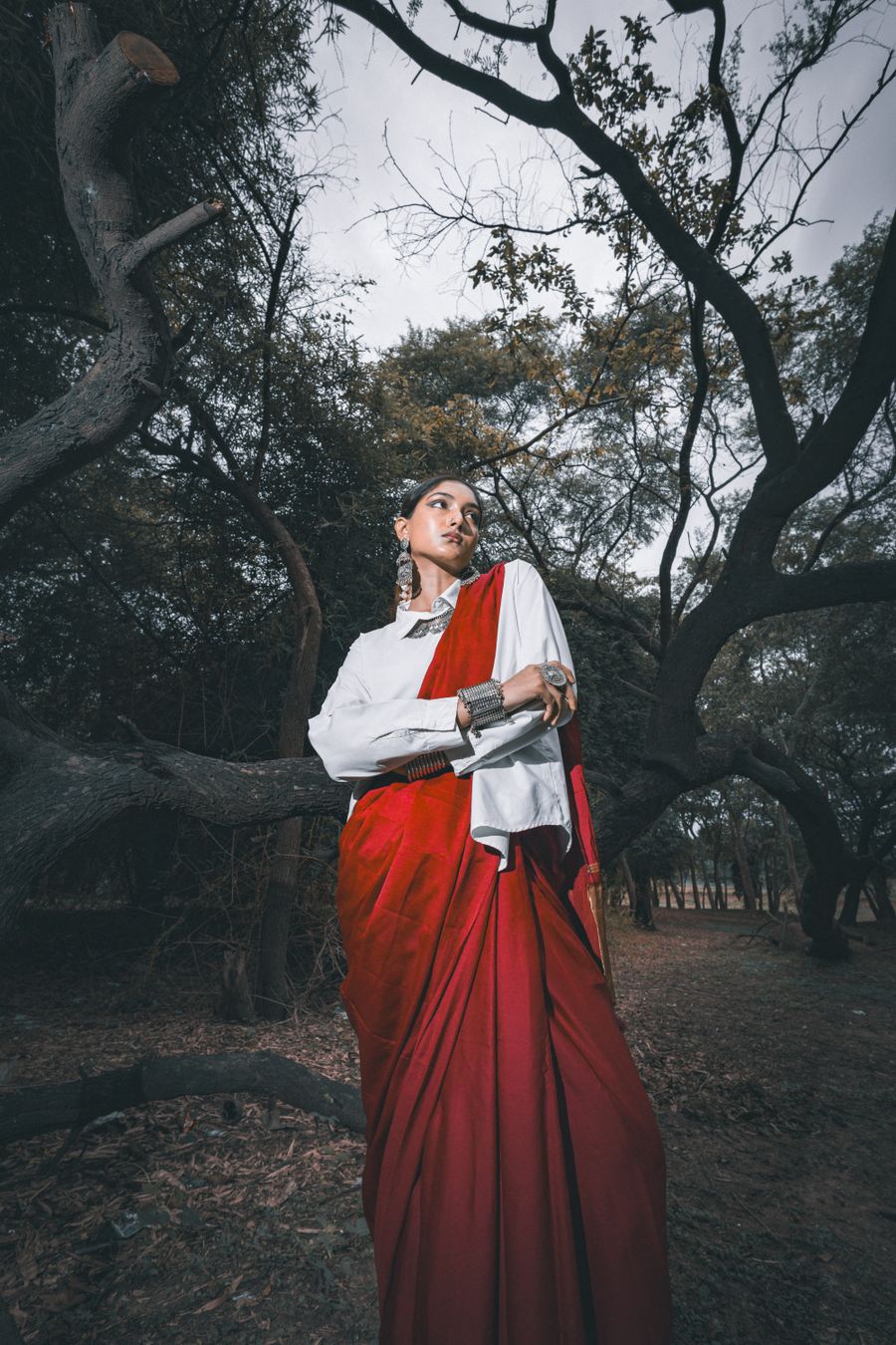 Elegant woman in red saree amidst forest — Start designing free phone mockup