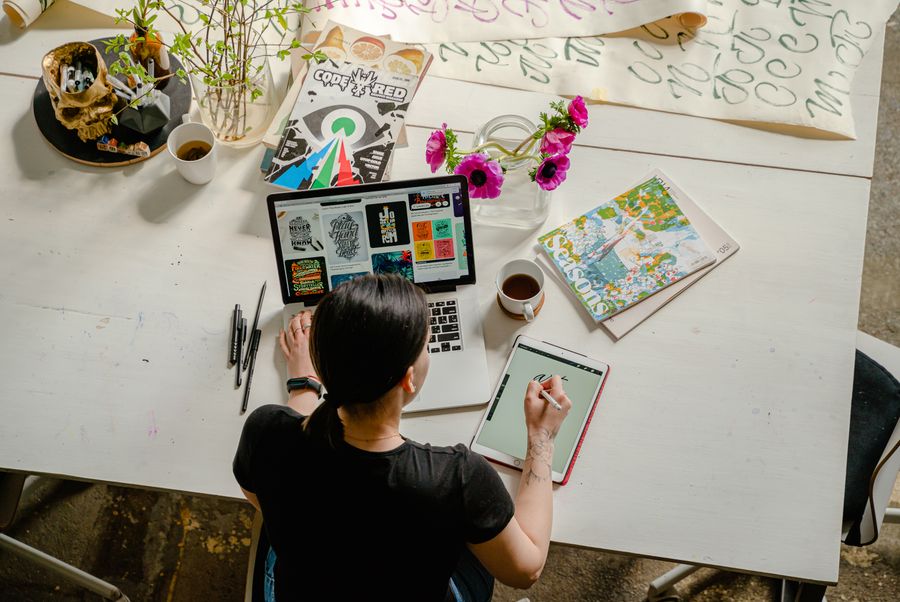 Photo of woman writing on tablet computer while using laptop — stock photo for Add a Shape