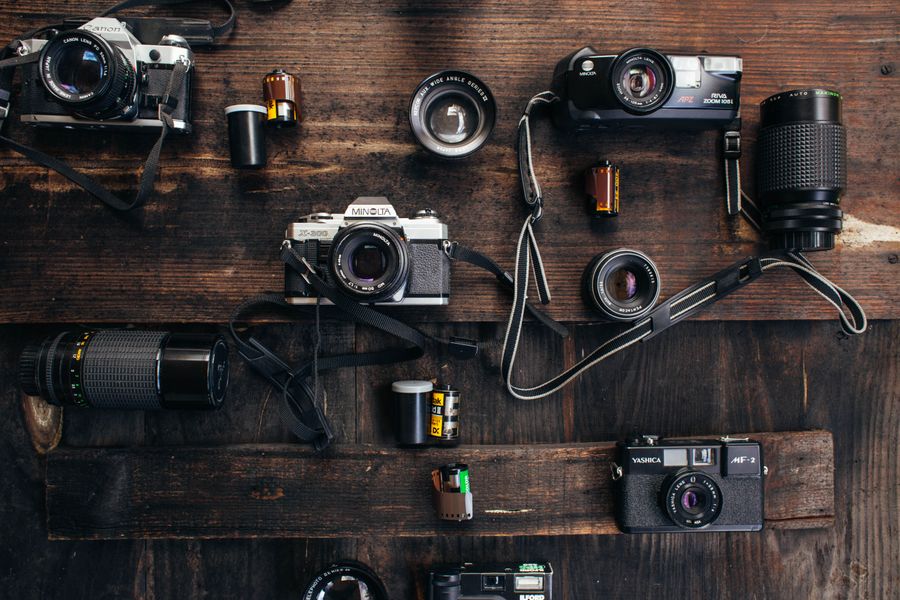 Vintage cameras and lenses near camera roll on table — stock photo for Everything in the editor, honestly described