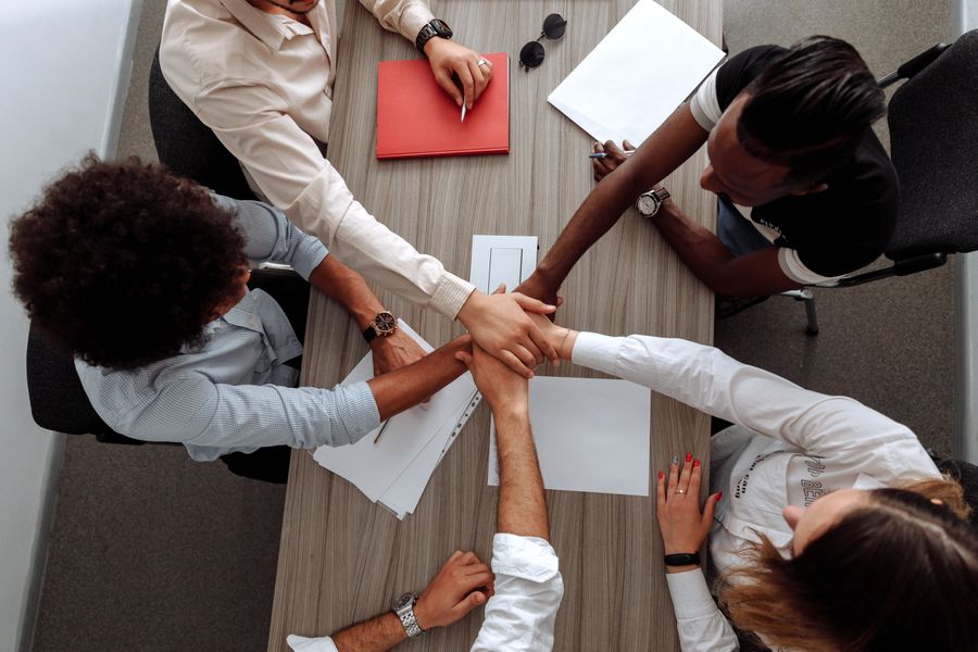 Coworkers with their hands together — Create a Design phone mockup