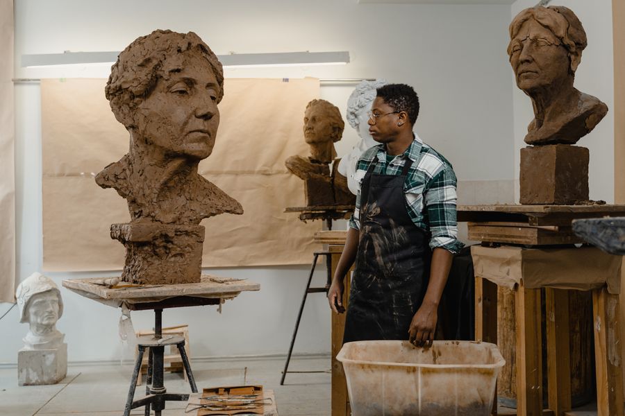 A sculptor in an apron looking at a sculpture — Browse Design Templates editor mockup