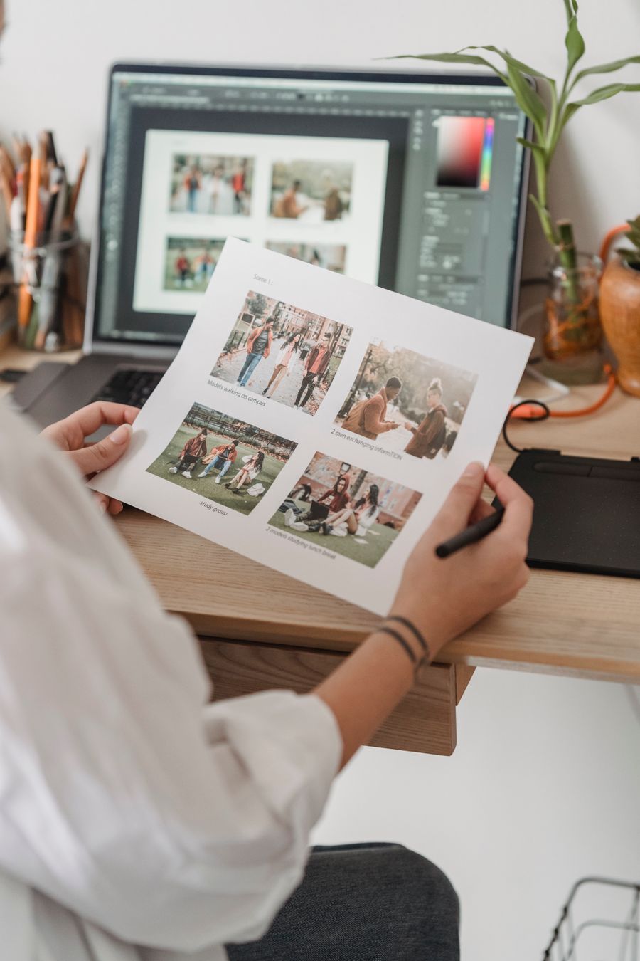 Woman with printed pictures sitting at table with laptop — PhotoAI Company — AI photo & design editor editor mockup