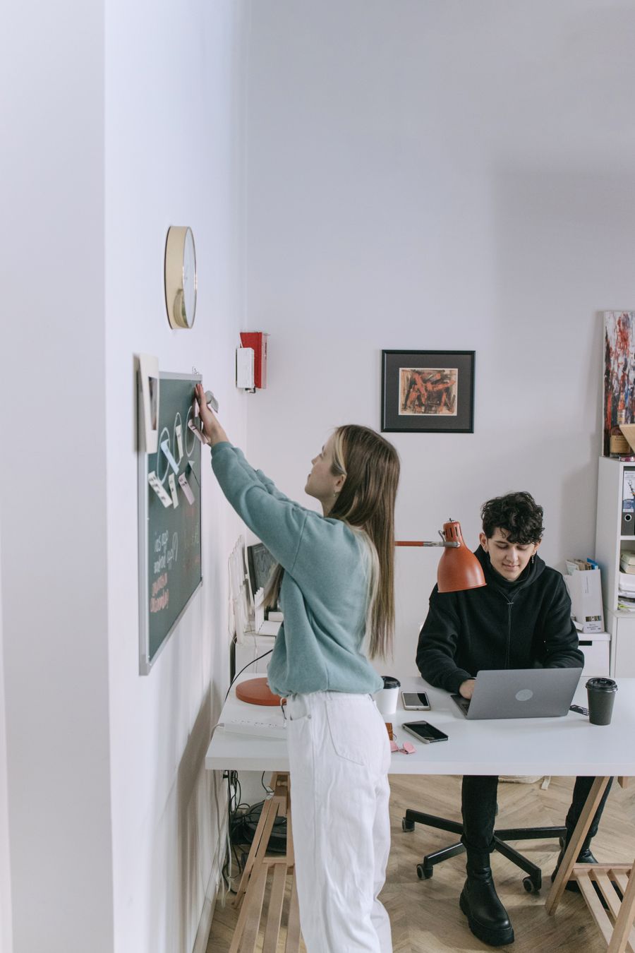 A woman sticking notes on the board — Advertisements in use