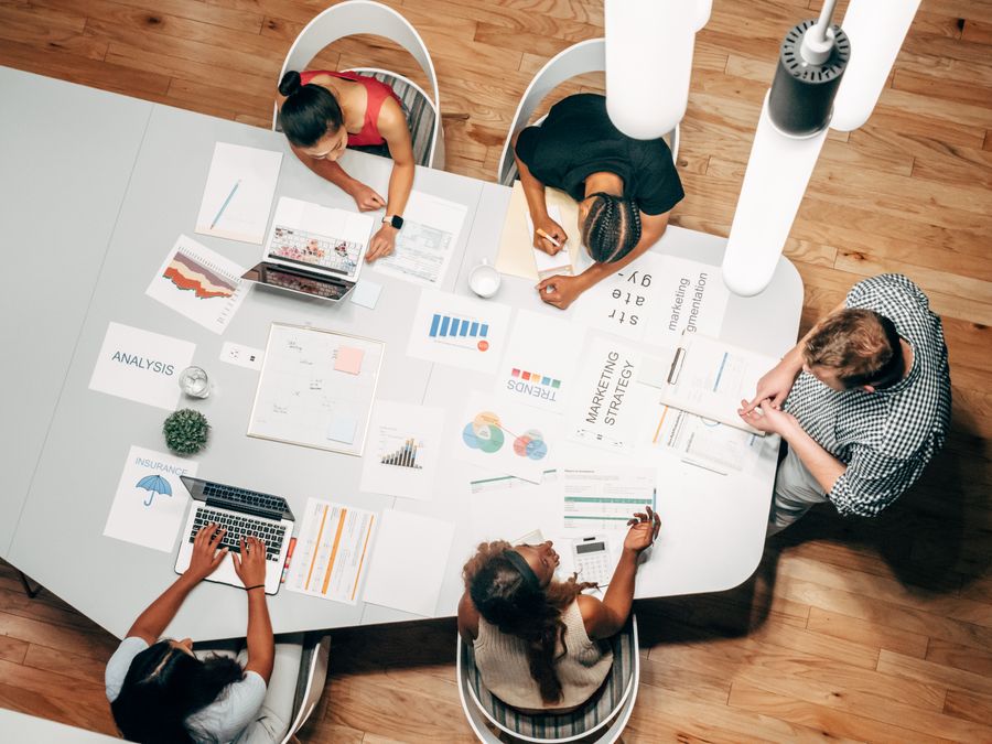 Overhead shot of people in a meeting — Every photoaicompany design tool dashboard mockup
