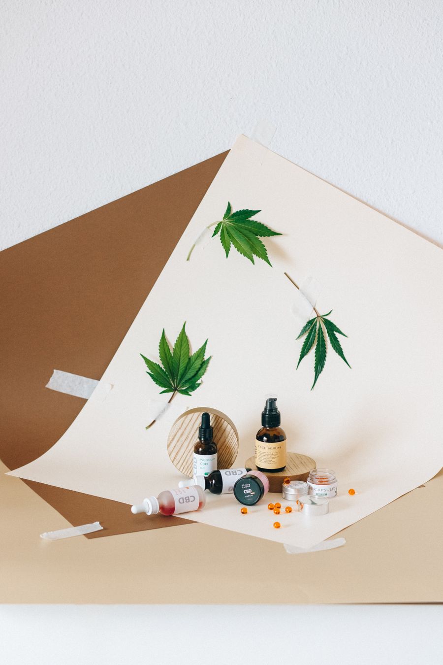 Bottles of hemp and cbd oil on white board with hemp leaves — before Suggest a Color Palette