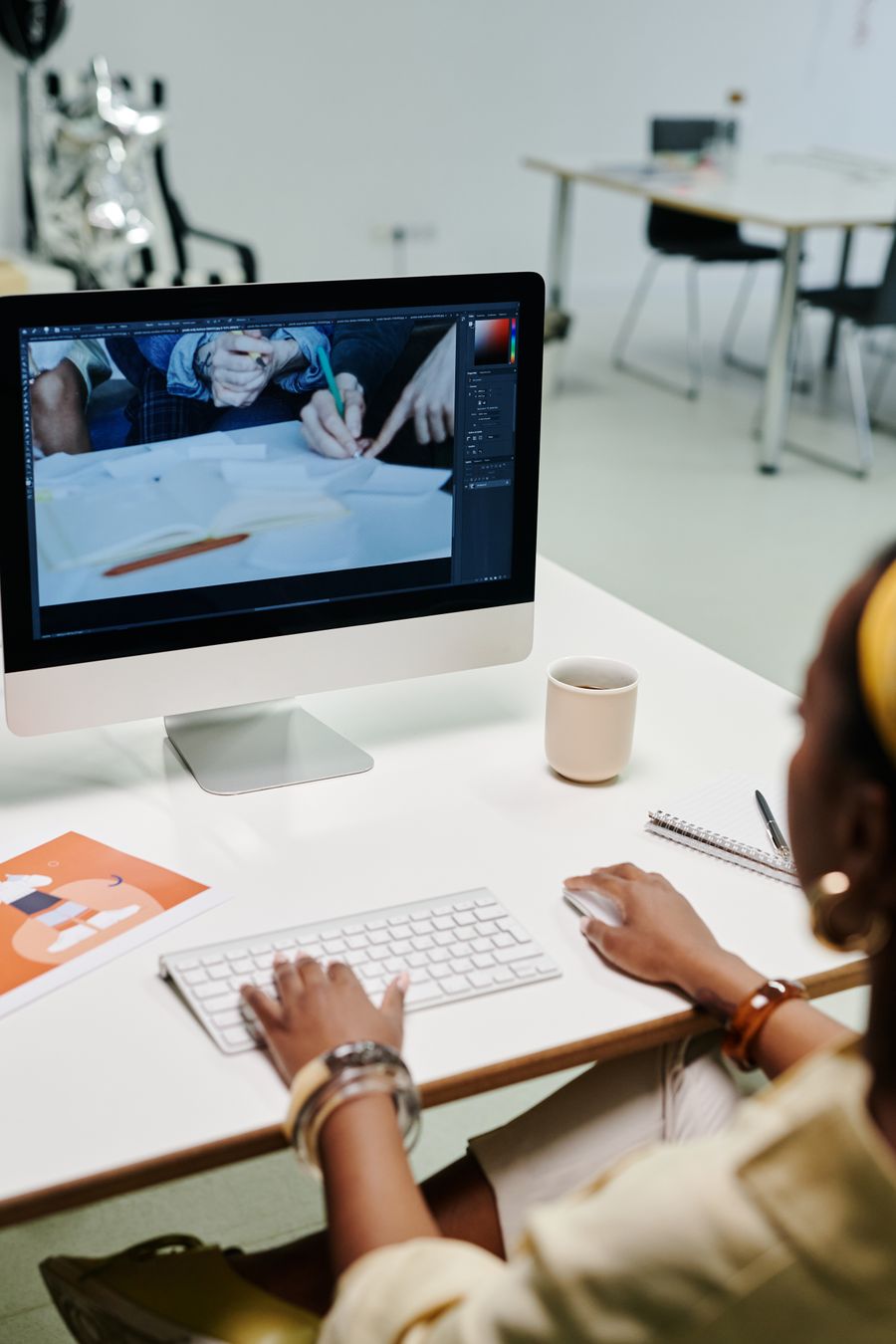 A person using an imac — stock photo for PhotoAI Company — AI photo & design editor