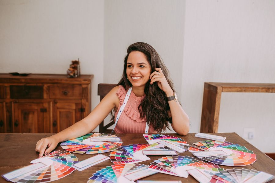 Smiling woman sitting at desk with color samples — Terms of Service layers-panel mockup
